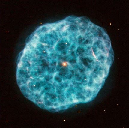 This new image from Hubble’s Wide Field Planetary Camera 2 showcases NGC 1501, a complex planetary nebula located in the large but faint constellation of Camelopardalis (The Giraffe). Discovered by William Herschel in 1787, NGC 1501 is a planetary nebula that is just under 5000 light-years away from us. Astronomers have modelled the three-dimensional structure of the nebula, finding it to be a cloud shaped as an irregular ellipsoid filled with bumpy and bubbly regions. It has a bright central star that can be seen easily in this image, shining brightly from within the nebula’s cloud. This bright pearl embedded within its glowing shell inspired the nebula’s popular nickname: the Oyster Nebula. While NGC 1501's central star blasted off its outer shell long ago, it still remains very hot and luminous, although it is quite tricky for observers to spot through modest telescopes. This star has actually been the subject of many studies by astronomers due to one very unusual feature: it seems to be pulsating, varying quite significantly in brightness over a typical timescale of just half an hour. While variable stars are not unusual, it is uncommon to find one at the heart of a planetary nebula. It is important to note that the colours in this image are arbitrary. A version of this image was entered into the Hubble’s Hidden Treasures image processing competition by contestant Marc Canale. Links  Marc Canale on Flickr